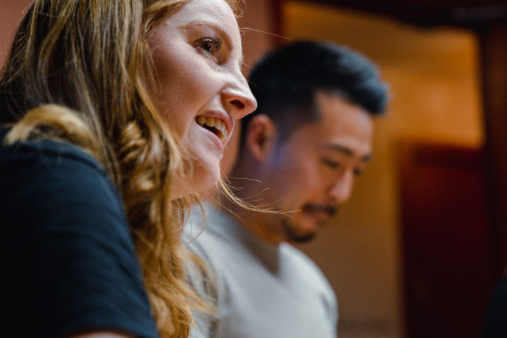 Two people sitting next to each other with a blurred background