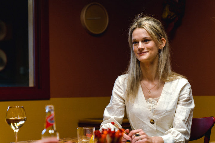 Woman sitting at table holding a pen